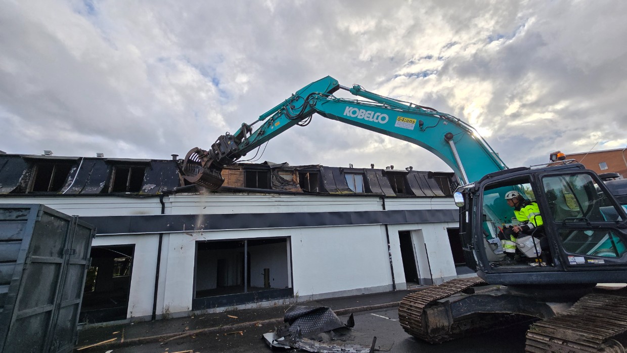 En grävmaskin demonterar huset