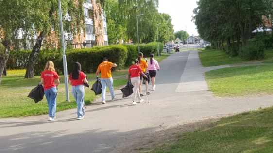 Ungdomarna i aktiv sommar med soppåsar i full färd att städa på sitt bostadsområde