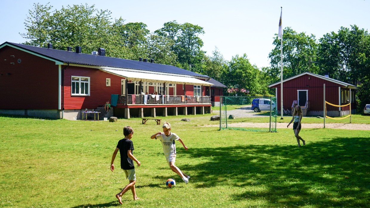 Barn spelar fotboll på kollot